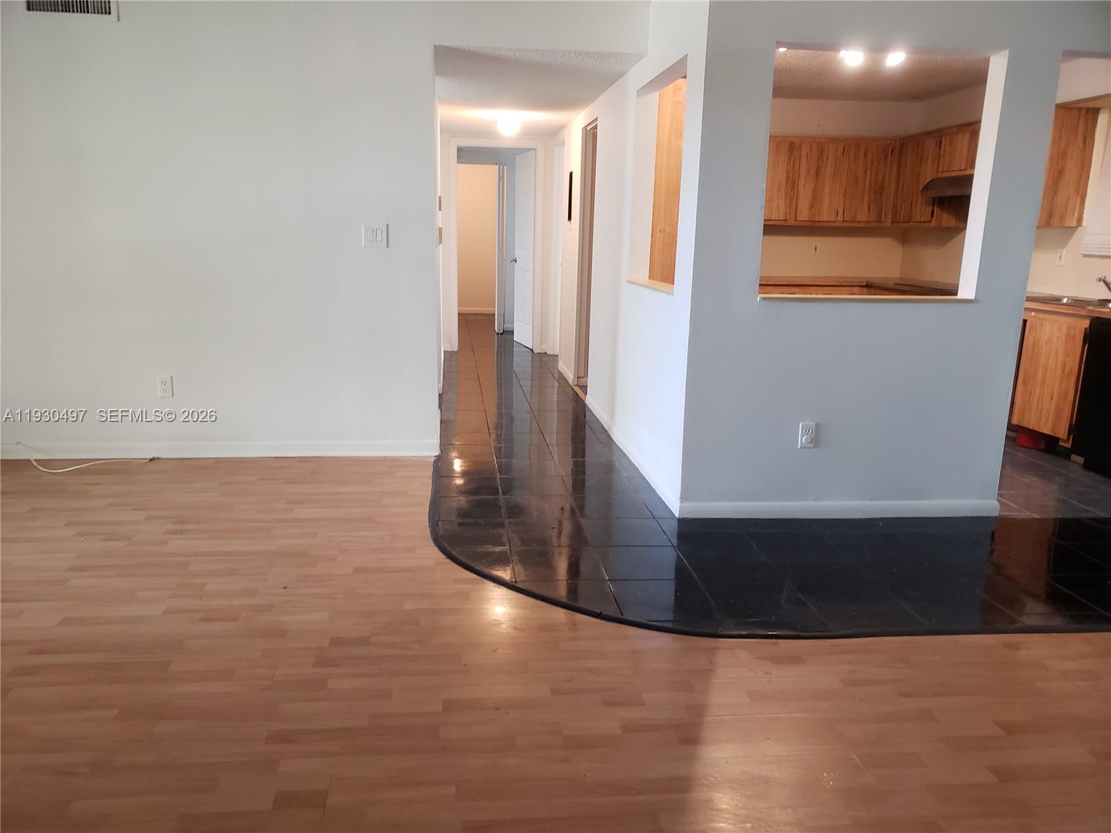 a view of a kitchen with wooden floor and a window