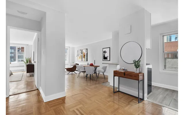 a living room with furniture a rug a lamp and a window