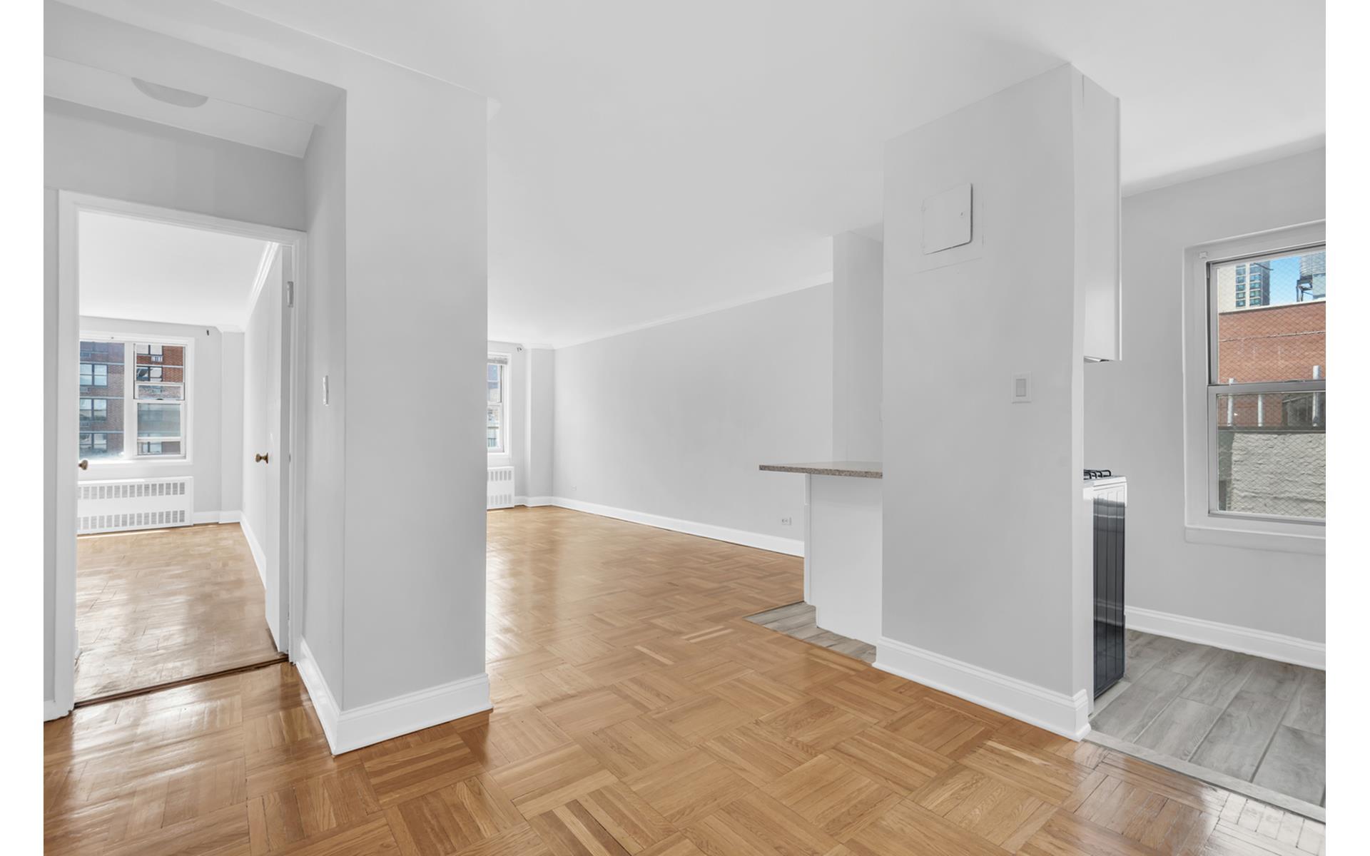 435 East 77th Street, Unit 8F Manhattan, NY 10075 - Photo 4 of 8 a view of a hallway with wooden floor and a living room