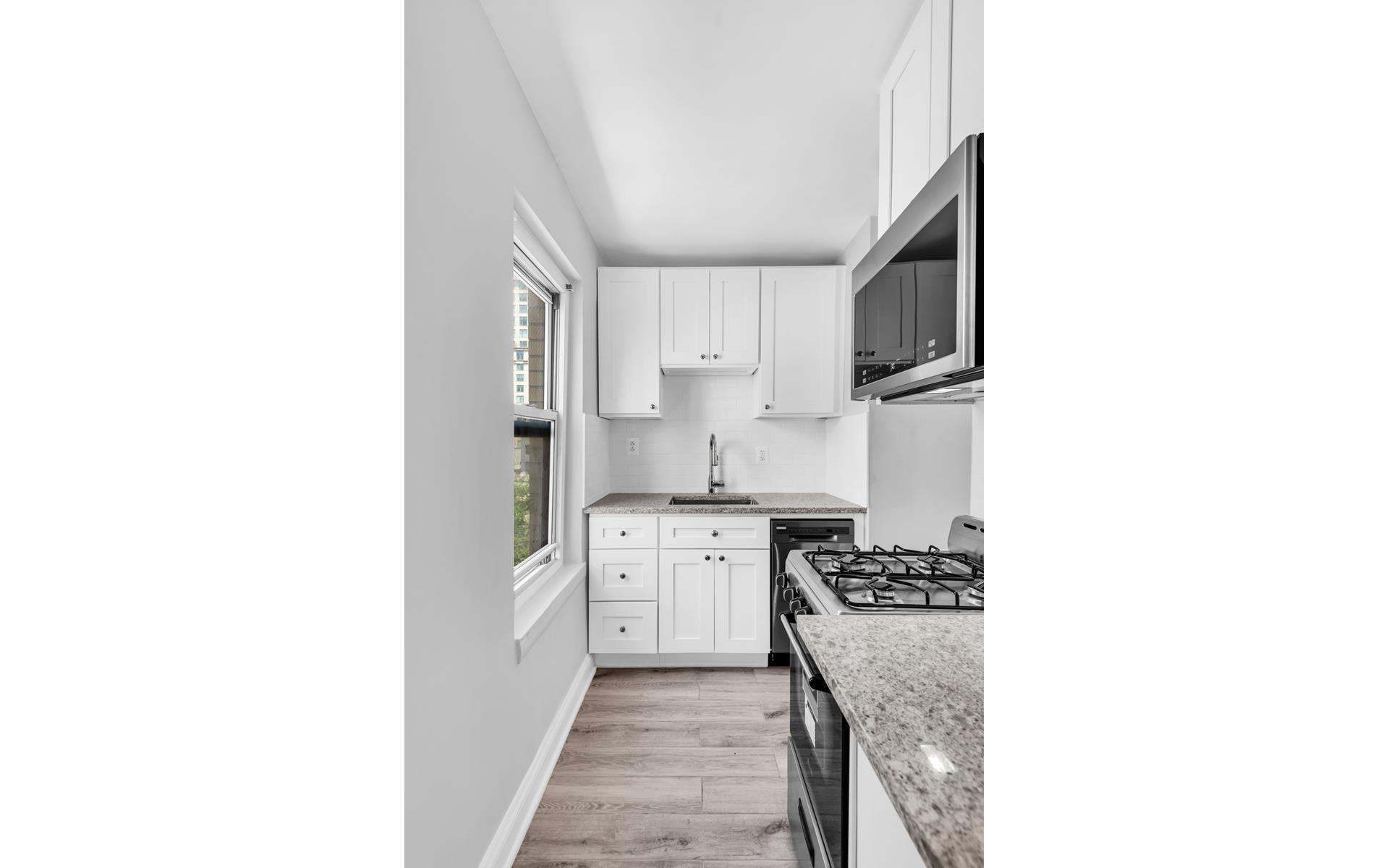 435 East 77th Street, Unit 8F Manhattan, NY 10075 - Photo 7 of 8 a kitchen with stainless steel appliances granite countertop a sink and cabinets