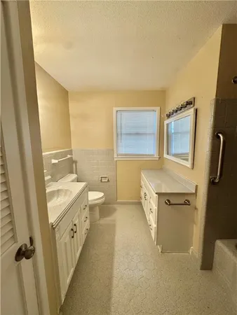 a bathroom with a granite countertop sink toilet and shower