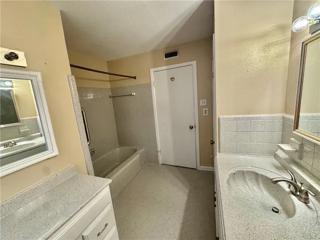 a bathroom with a sink a toilet a mirror and shower