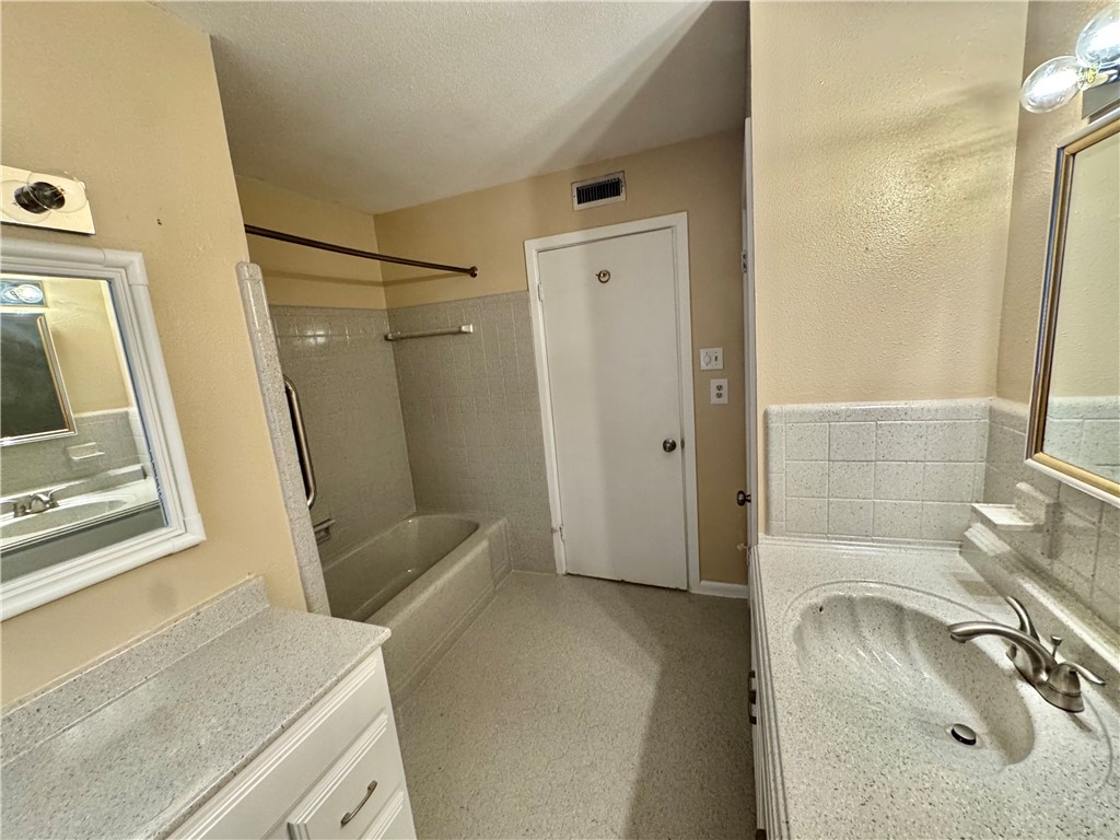 614 Dolphin Place Corpus Christi, TX 78411 - Photo 12 of 23 a bathroom with a sink a toilet a mirror and shower