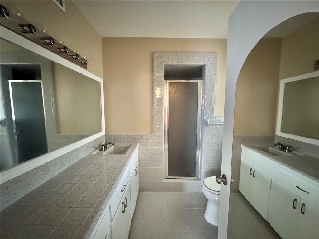 614 Dolphin Place Corpus Christi, TX 78411 - Photo 16 of 23 a bathroom with a granite countertop sink toilet and shower
