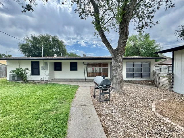 a backyard of a house with table and chairs