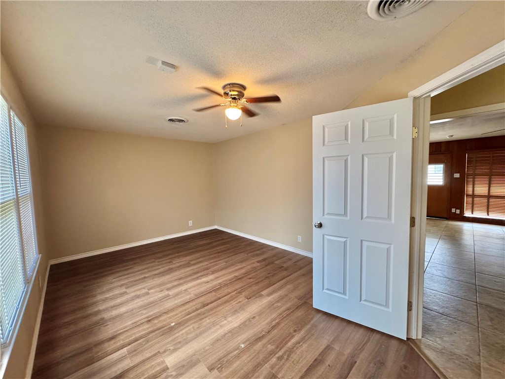 614 Dolphin Place Corpus Christi, TX 78411 - Photo 4 of 23 wooden floor in an empty room with a window