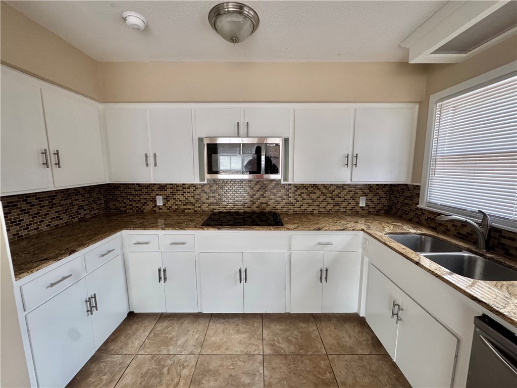 614 Dolphin Place Corpus Christi, TX 78411 - Photo 8 of 23 a kitchen with granite countertop white cabinets and stainless steel appliances