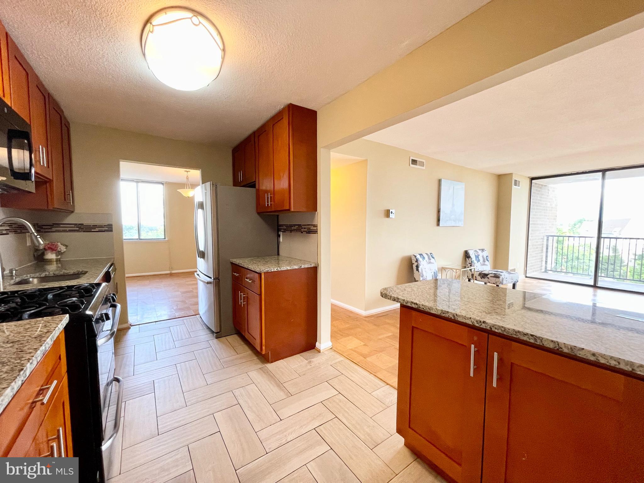 4 Monroe Street, Unit 802 Rockville, MD 20850 - Photo 17 of 44 a kitchen with stainless steel appliances granite countertop a sink stove and cabinets
