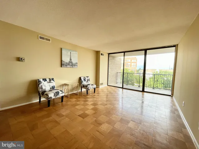 a living room with furniture and a floor to ceiling window
