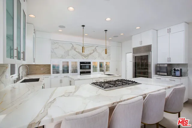 a kitchen with stainless steel appliances kitchen island granite countertop a stove a sink a refrigerator and a cabinets