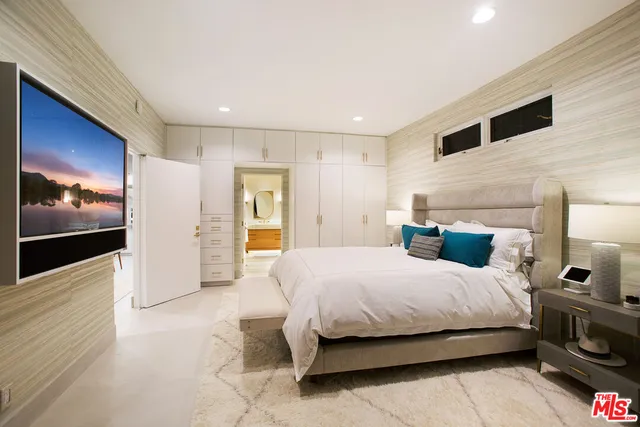 a bedroom with a large bed and a view of living room