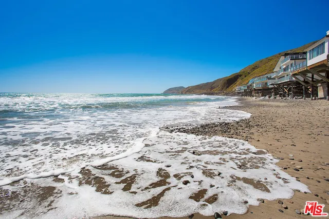 a view of a patio with couches table and chairs with wooden floor and fence