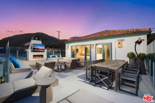 a patio with tables and chairs and a fire pit