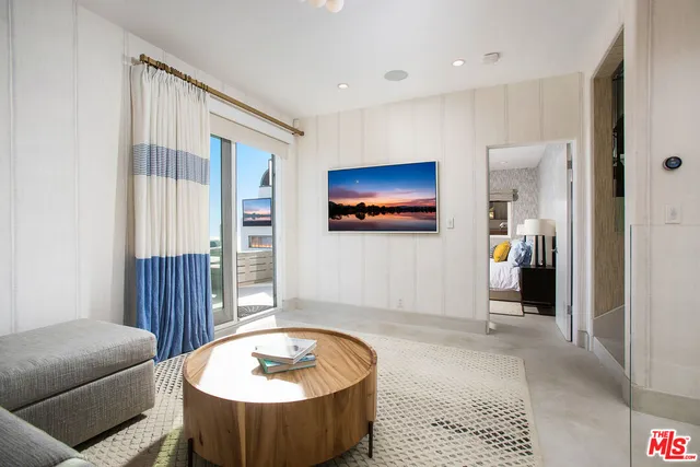 a living room with furniture flat screen tv and couches