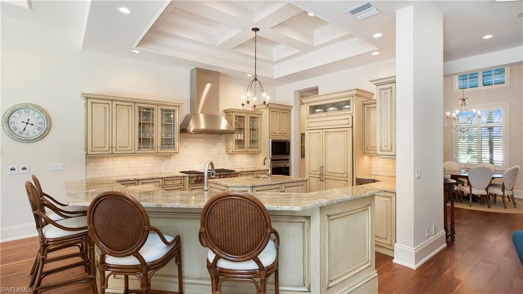 645 Rudder Road Naples, FL 34102 - Photo 15 of 45 a kitchen with stainless steel appliances granite countertop a dining table chairs cabinets and a sink