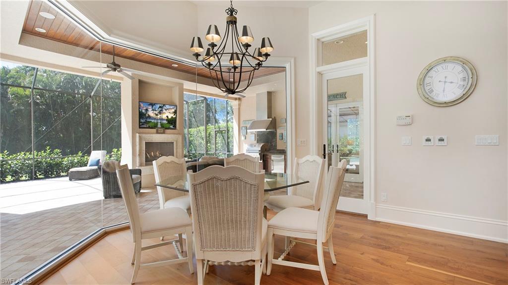 645 Rudder Road Naples, FL 34102 - Photo 17 of 45 a view of a dining room with furniture a chandelier and wooden floor