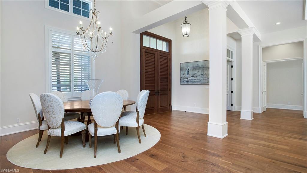 645 Rudder Road Naples, FL 34102 - Photo 18 of 45 a dining room with furniture a chandelier and wooden floor