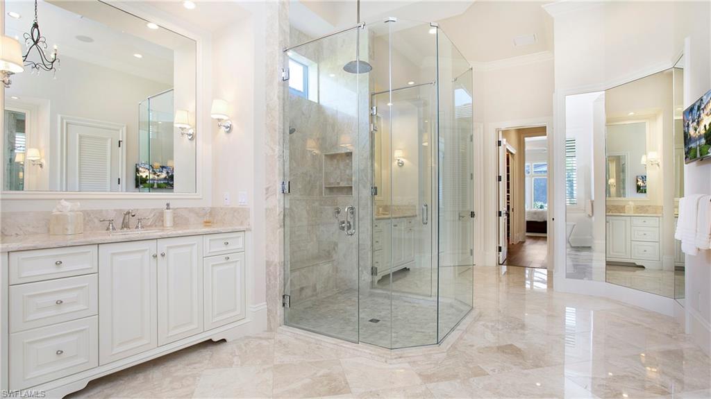 645 Rudder Road Naples, FL 34102 - Photo 22 of 45 a bathroom with a shower sink and mirror