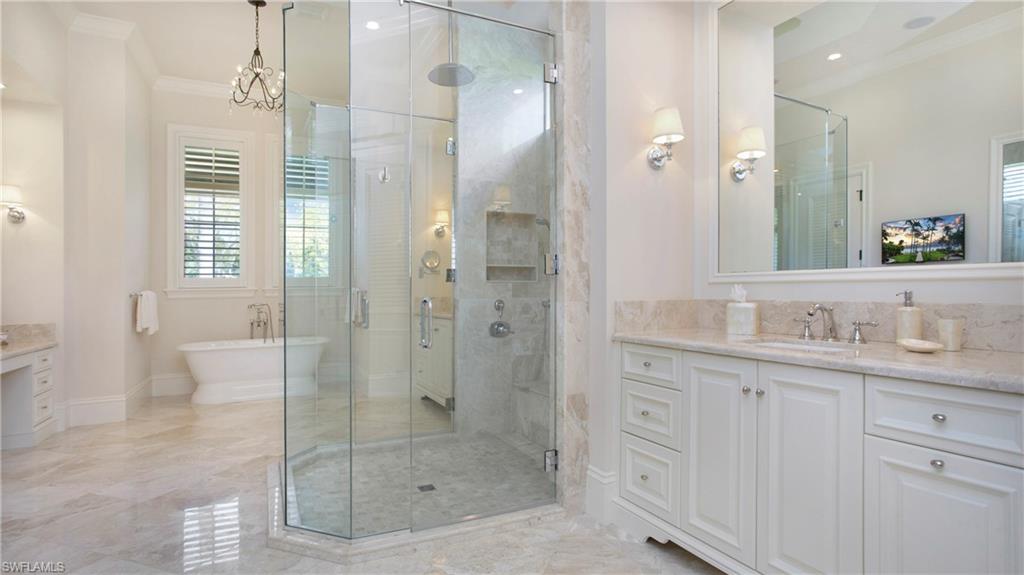645 Rudder Road Naples, FL 34102 - Photo 25 of 45 a bathroom with a shower sink and mirror