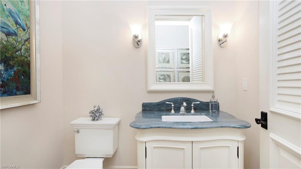 645 Rudder Road Naples, FL 34102 - Photo 27 of 45 a bathroom with a toilet sink and mirror