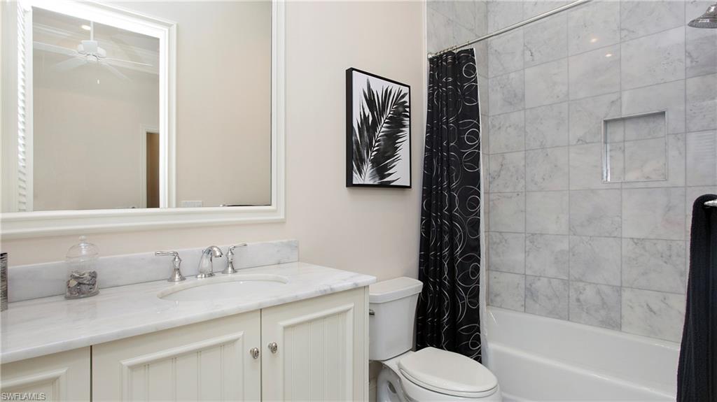 645 Rudder Road Naples, FL 34102 - Photo 29 of 45 a bathroom with a granite countertop sink toilet and shower