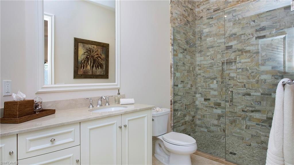 645 Rudder Road Naples, FL 34102 - Photo 35 of 45 a bathroom with a granite countertop sink toilet and a mirror