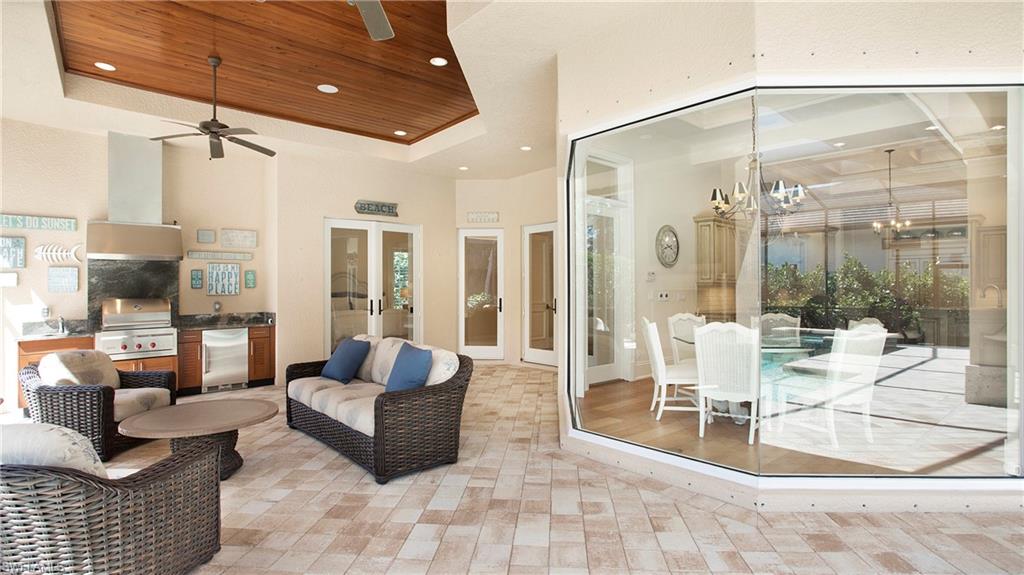645 Rudder Road Naples, FL 34102 - Photo 40 of 45 a living room with furniture and a floor to ceiling window