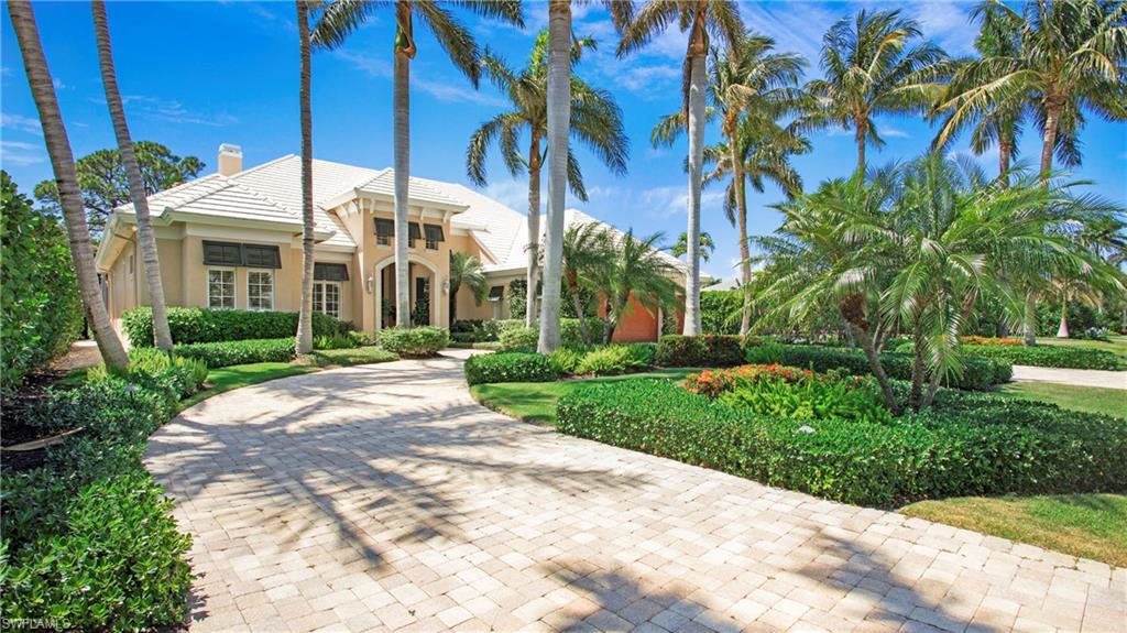 645 Rudder Road Naples, FL 34102 - Photo 4 of 45 a view of a white house with a yard and potted plants