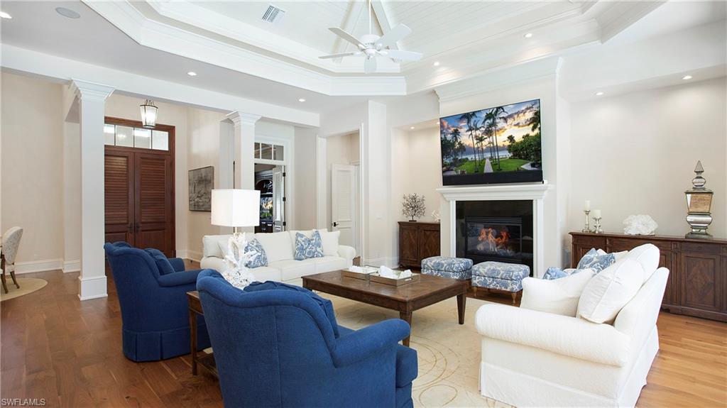 645 Rudder Road Naples, FL 34102 - Photo 8 of 45 a living room with furniture a flat screen tv and a fireplace