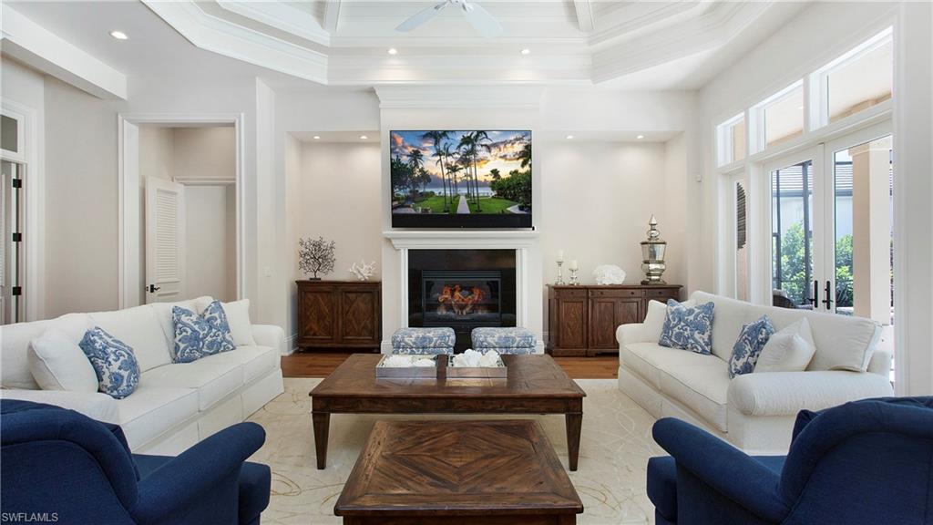 645 Rudder Road Naples, FL 34102 - Photo 9 of 45 a living room with furniture a flat screen tv and a fireplace