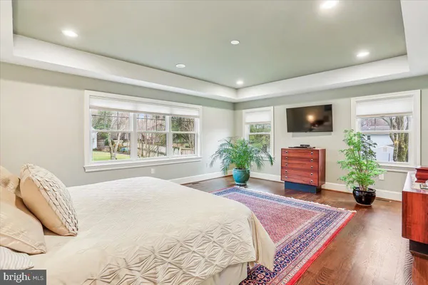 a view of a bedroom with a bed and wooden floor
