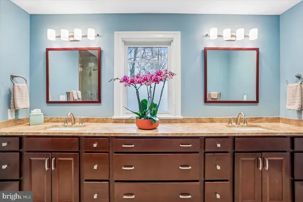 a bathroom with a sink a mirror and a window