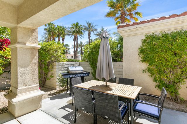 a view of a patio with a table and chairs and potted plants