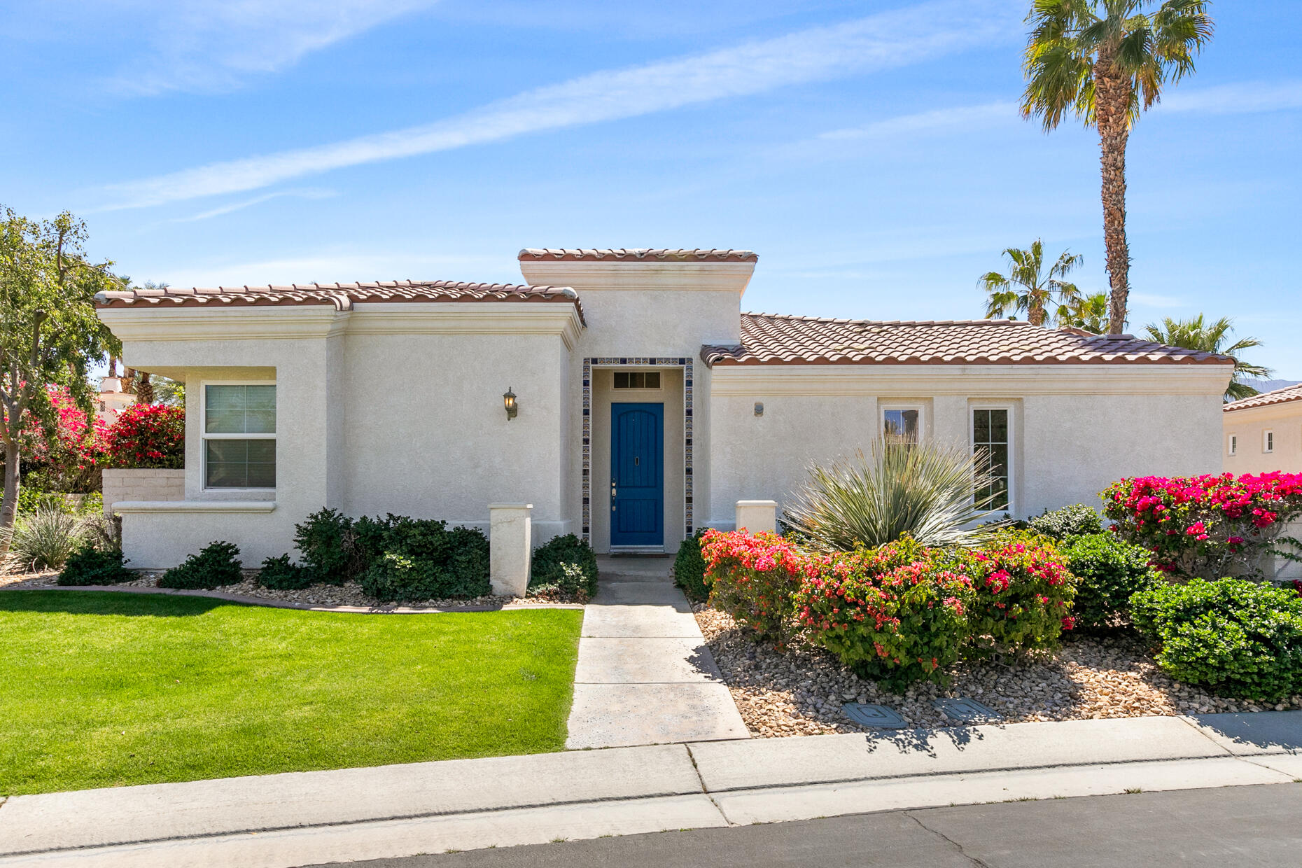80919 Via Puerta Azul La Quinta, CA 92253 - Photo 2 of 32 a front view of a house with a garden and yard
