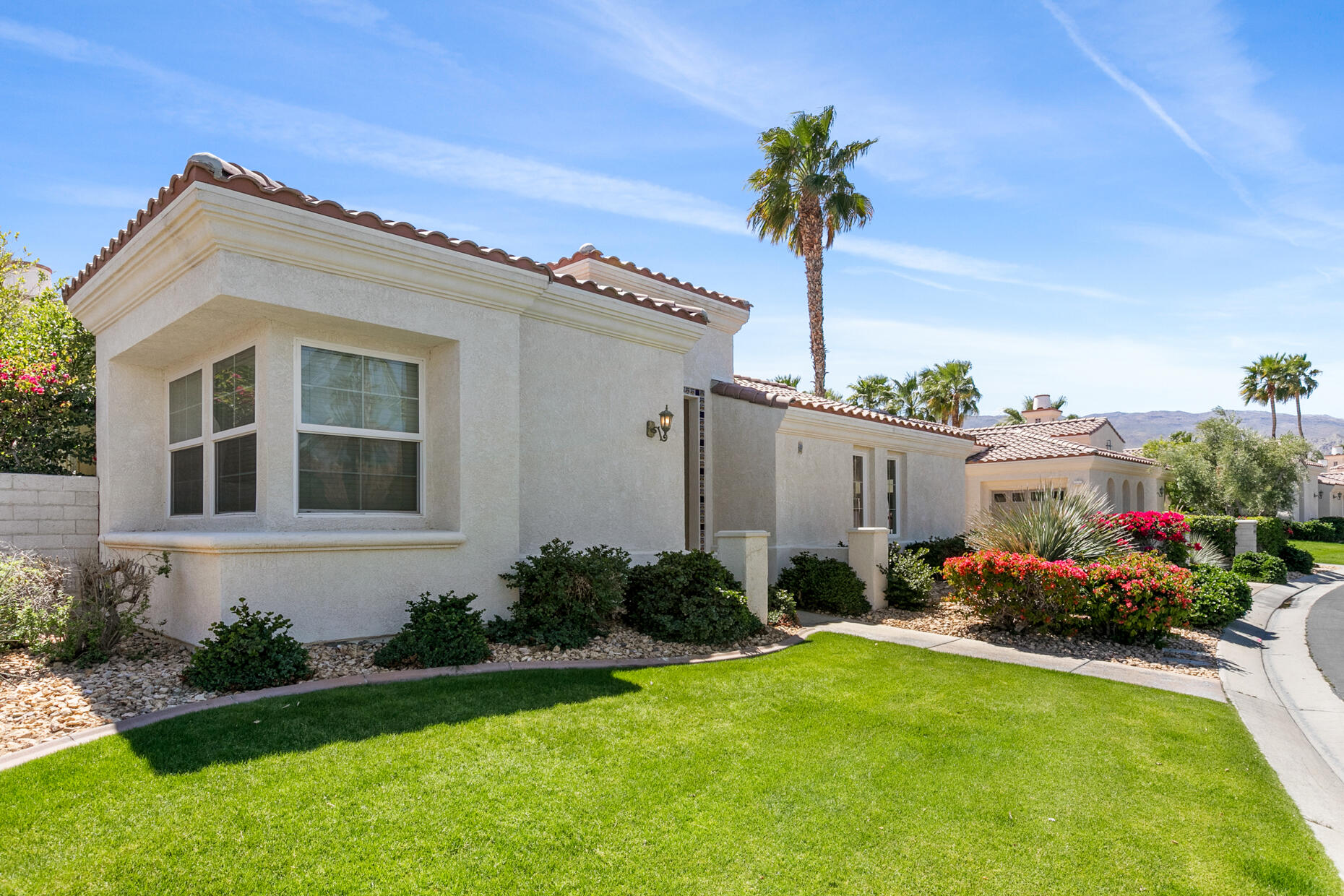80919 Via Puerta Azul La Quinta, CA 92253 - Photo 21 of 32 a front view of a house with garden