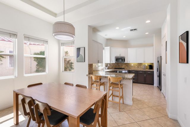 a kitchen with a dining table chairs and refrigerator