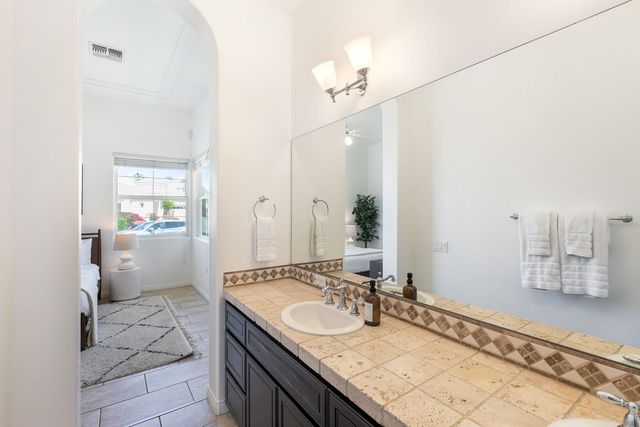 a bathroom with a granite countertop sink a mirror and a shower