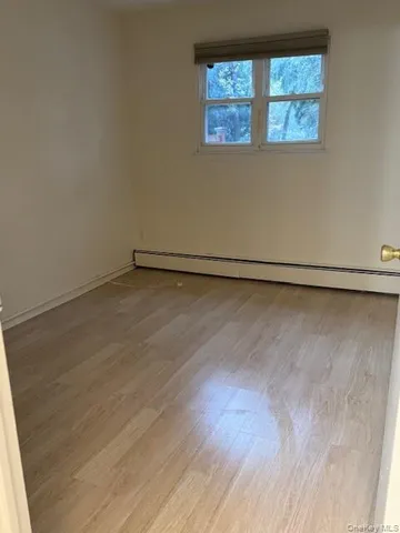 a view of a small space with wooden floor and a window