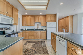19 East Southfield Road Spanish Fork, UT 84660 - Photo 74 of 74 Kitchen with dark countertops, white appliances, and recessed lighting