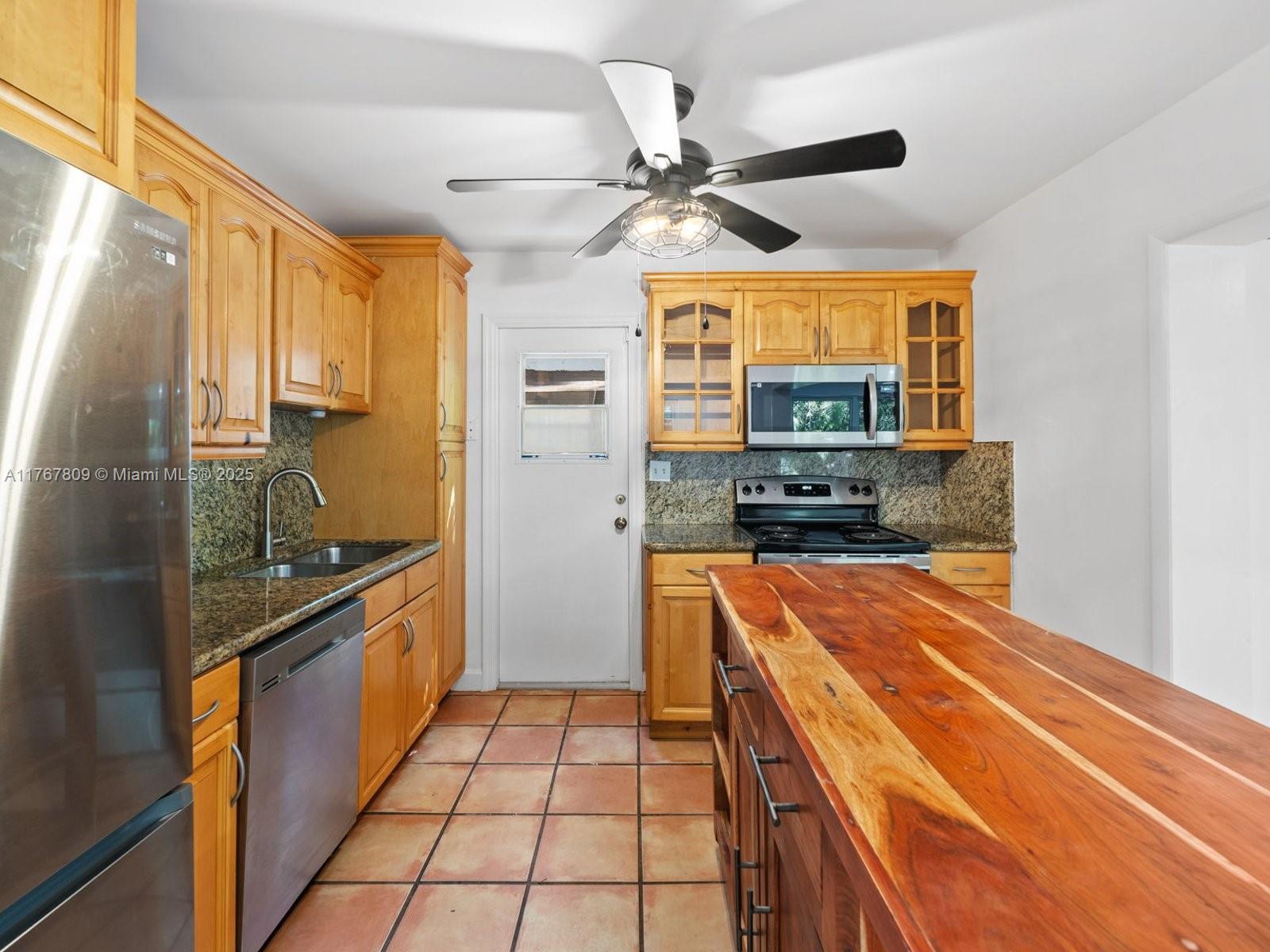 3631 Loquat Avenue Miami, FL 33133 - Photo 15 of 31 a kitchen with stainless steel appliances granite countertop a sink and a refrigerator