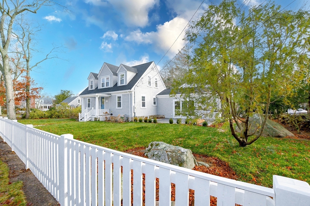 a view of a house with backyard and a tree