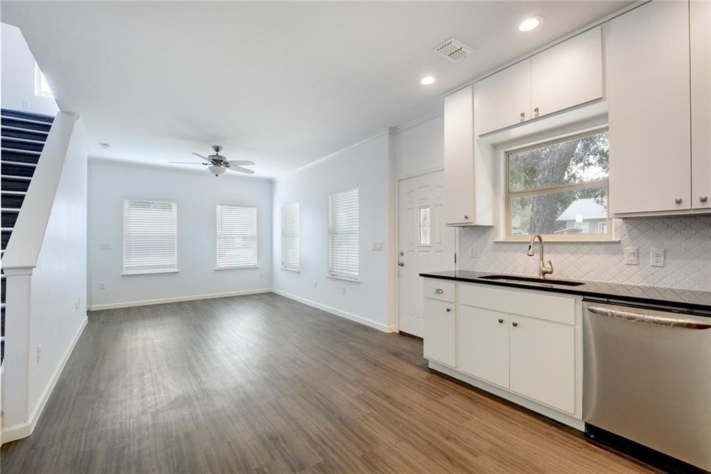 a kitchen with granite countertop a sink cabinets and wooden floor