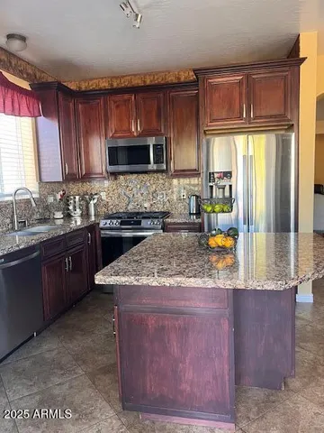 a kitchen with stainless steel appliances granite countertop a sink a stove a microwave a counter top and cabinets