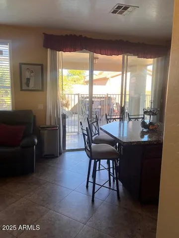 a dining room with furniture and a floor to ceiling window