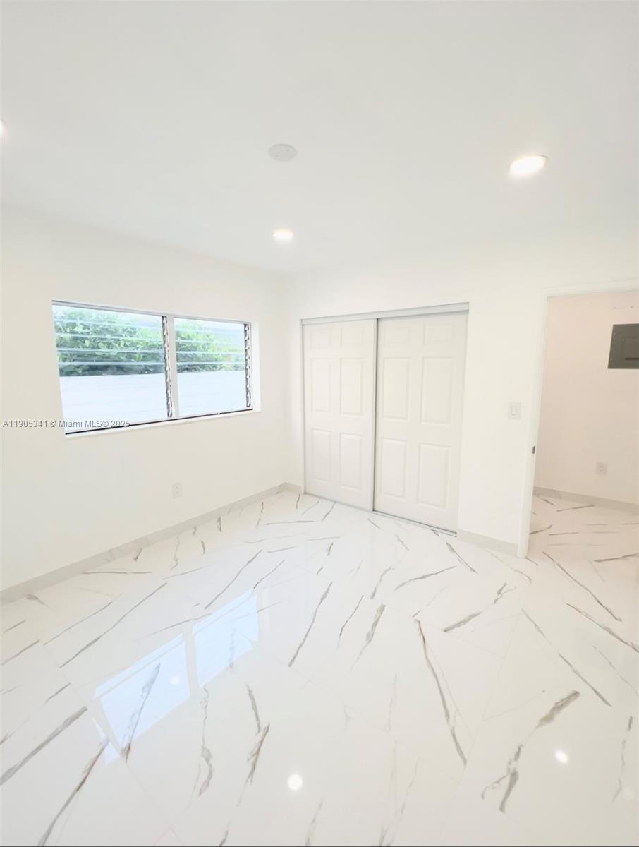 7300 Byron Avenue, Unit 10 Miami Beach, FL 33141 - Photo 7 of 10 an empty room with a empty space and windows