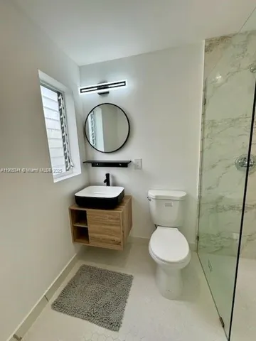 a white toilet sitting next to a bathroom sink