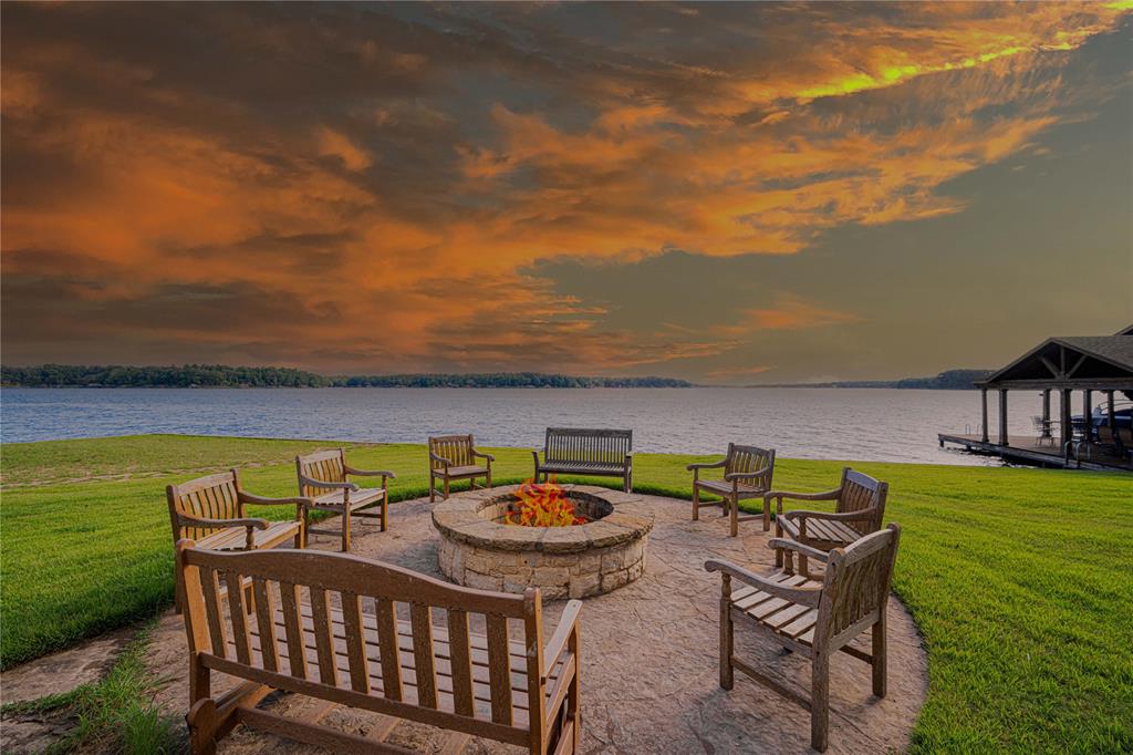 582 Windy Point Mount Vernon, TX 75457 - Photo 3 of 38 Patio terrace at dusk featuring an outdoor fire pit, a yard, and a water view