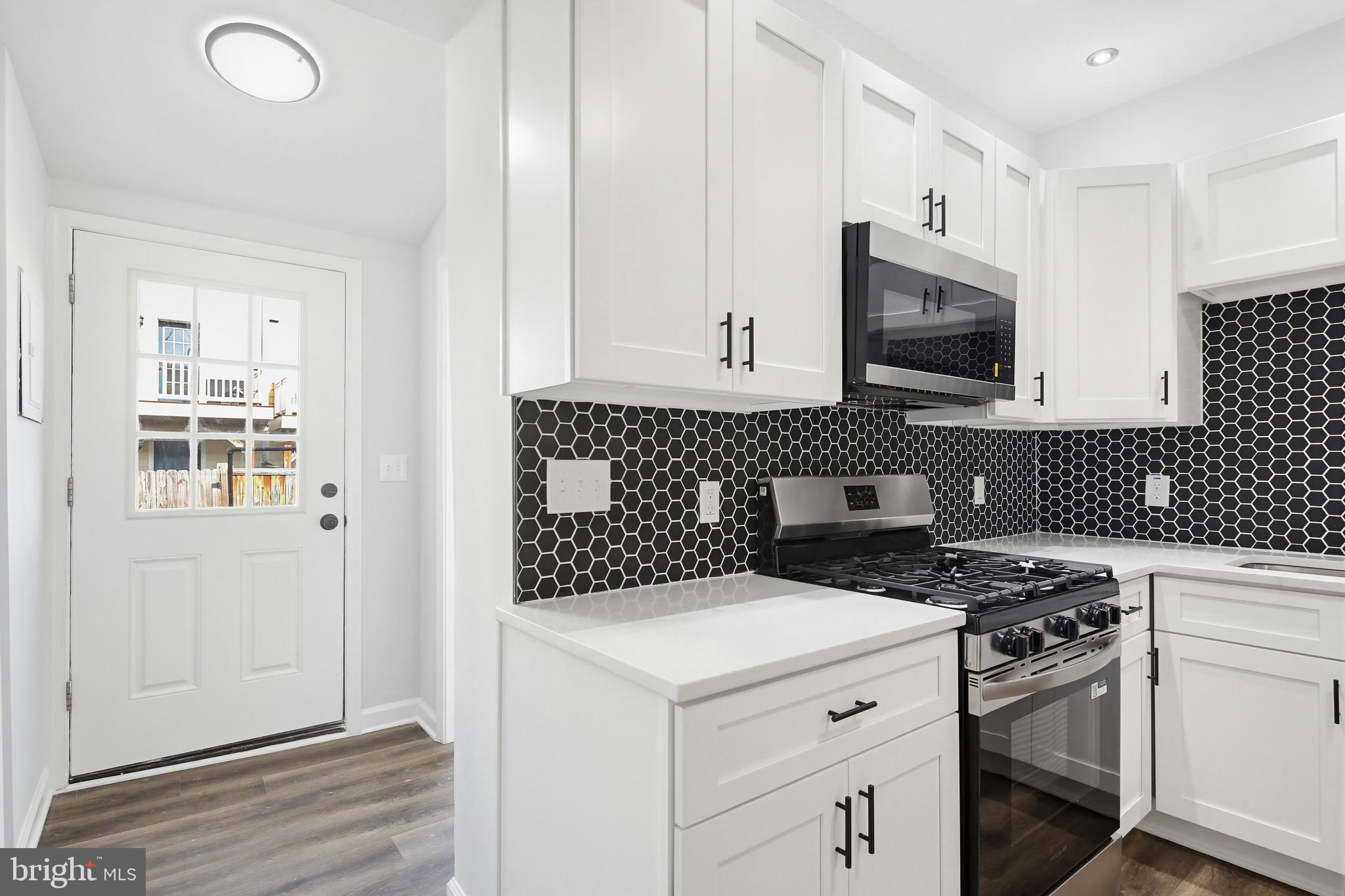 1244 Carroll Street Baltimore, MD 21230 - Photo 29 of 30 a kitchen with a stove a sink and a microwave
