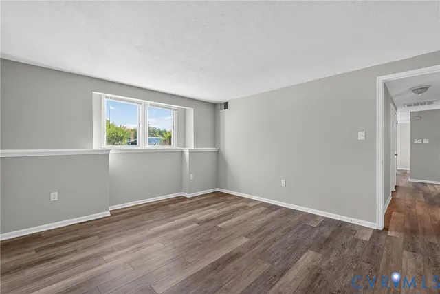 a view of an empty room and wooden floor