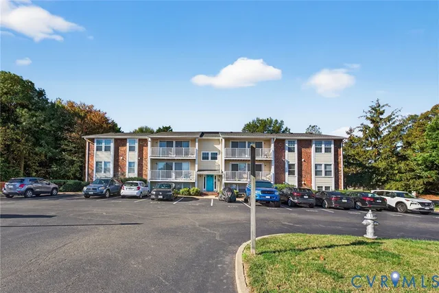 a view of a building with cars parked